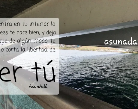 Debajo de un puente junto a un río repleto de agua. 