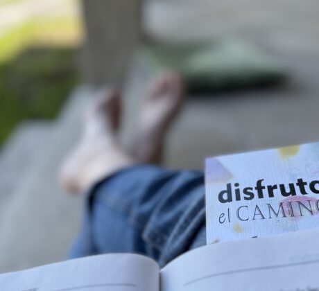 Disfruta el camino se lee en un marcador de un libro abierto, y unos pies - Asun Adá